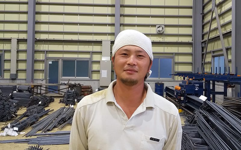 加工場内で笑顔を見せる村田鉄筋の社員